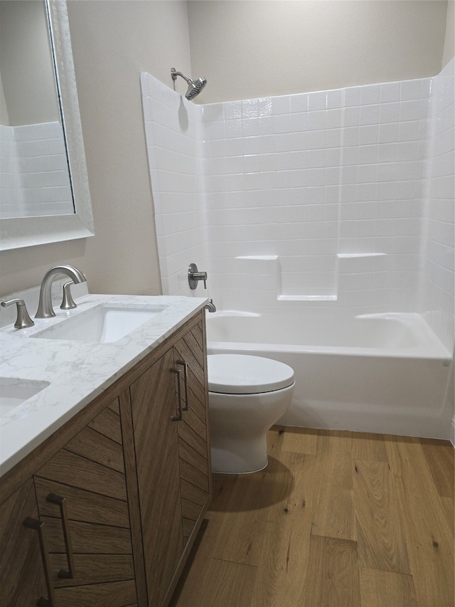 full bathroom with wood-type flooring,  shower combination, vanity, and toilet