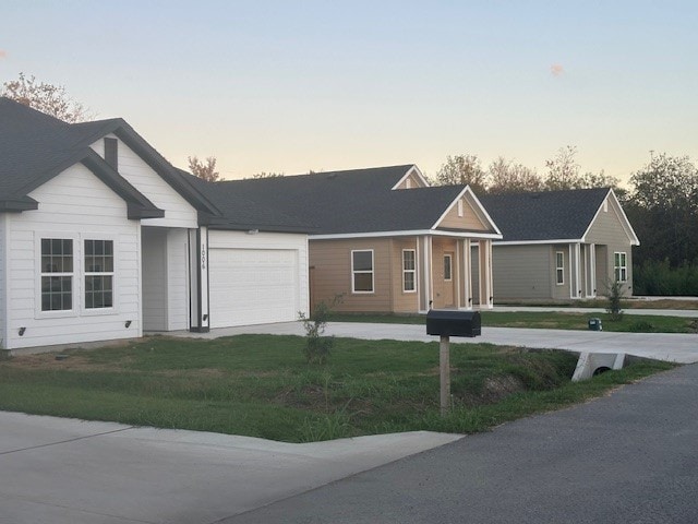 ranch-style home featuring a yard and a garage