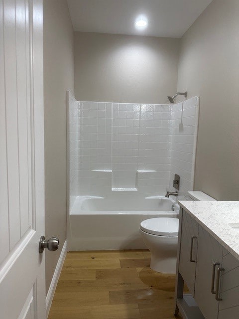 full bathroom with hardwood / wood-style floors, shower / bath combination, vanity, and toilet