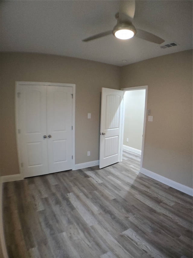 unfurnished bedroom with light hardwood / wood-style flooring, a closet, and ceiling fan