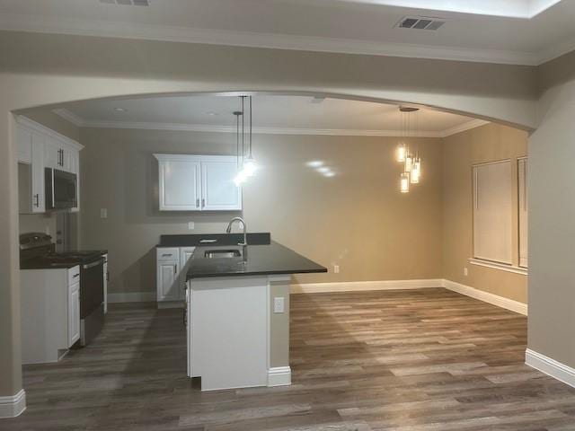 1010 S Preston St, Ennis, TX 75119 - kitchen featuring a sink, stainless steel microwave, dark countertops, electric range, and arched walkways