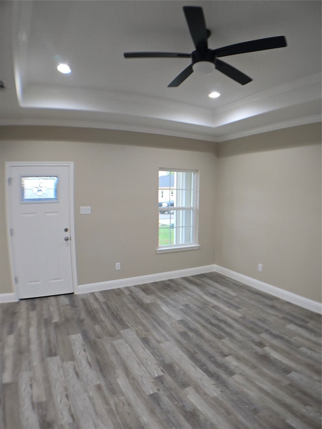 foyer entrance with a tray ceiling, ceiling fan, hardwood / wood-style flooring, and crown molding