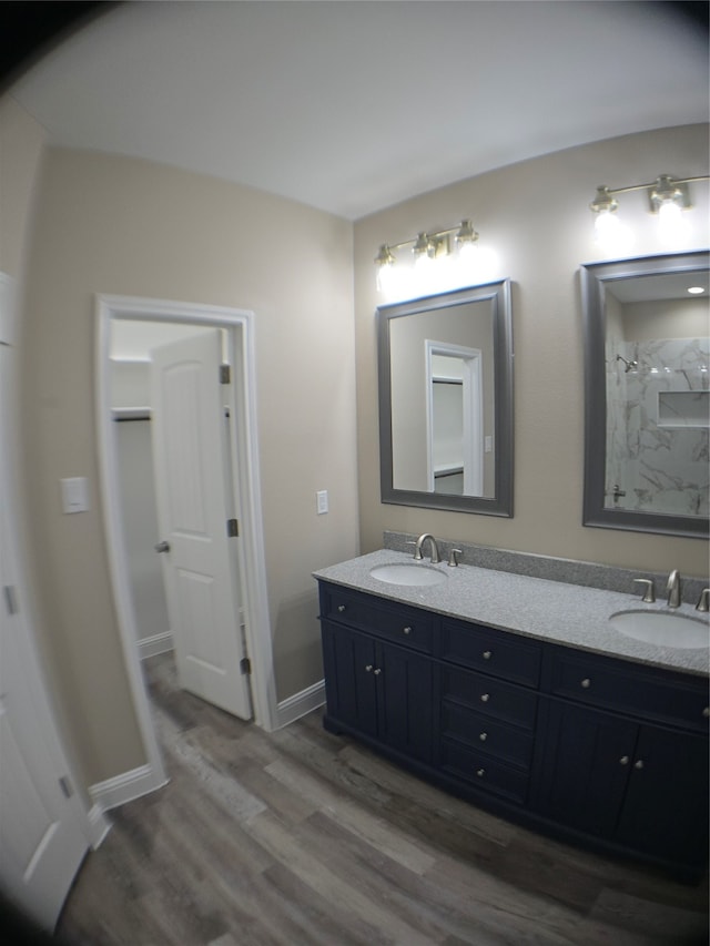 bathroom with hardwood / wood-style flooring, vanity, and a shower