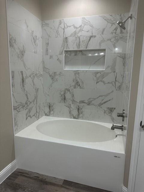 1010 S Preston St, Ennis, TX 75119 - full bathroom with tub / shower combination, wood finished floors, and baseboards