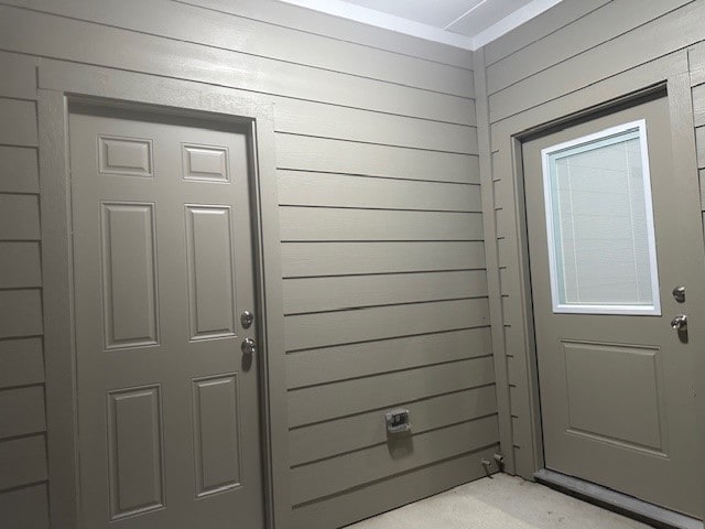 doorway to outside featuring wood walls