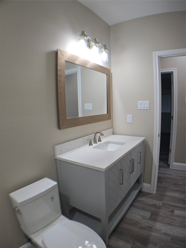 bathroom with vanity, toilet, and hardwood / wood-style flooring