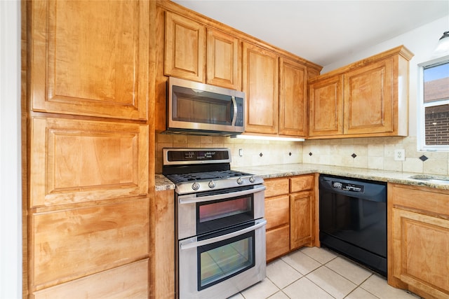 kitchen featuring light stone counters, stainless steel appliances, light tile patterned floors, and decorative backsplash