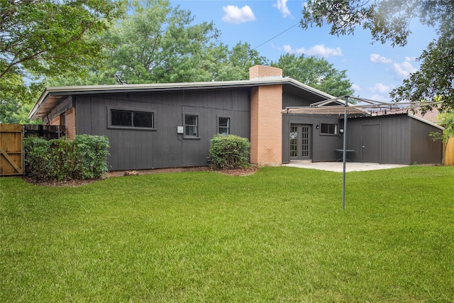 back of house with french doors, a lawn, and a patio area