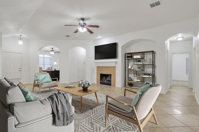 living area featuring arched walkways, light tile patterned floors, and visible vents