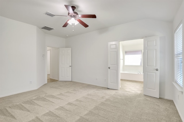 unfurnished bedroom with light carpet, ceiling fan, and ensuite bathroom