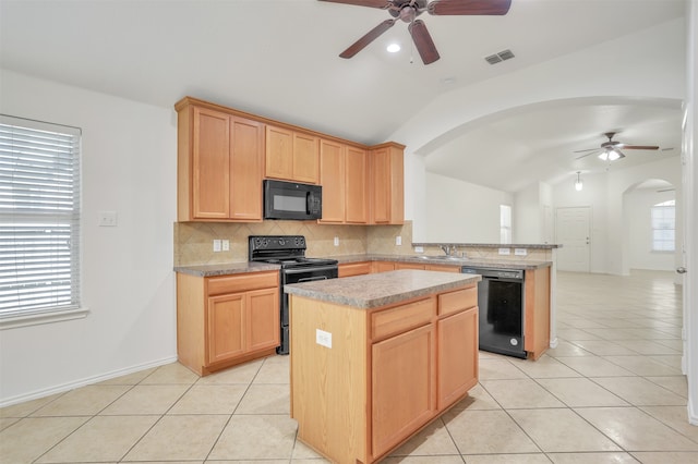 kitchen with vaulted ceiling, kitchen peninsula, a kitchen island, black appliances, and ceiling fan