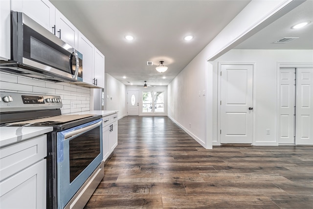 kitchen featuring stainless steel appliances, white cabinets, dark wood-type flooring, and tasteful backsplash