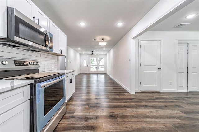 1504 Nichols St, Ennis, TX 75119 - kitchen featuring appliances with stainless steel finishes, dark wood-style floors, tasteful backsplash, light countertops, and white cabinets