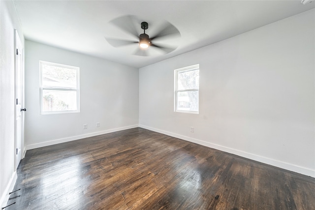 empty room with a wealth of natural light, ceiling fan, and dark hardwood / wood-style flooring