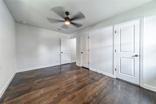 unfurnished bedroom featuring ceiling fan and dark hardwood / wood-style flooring