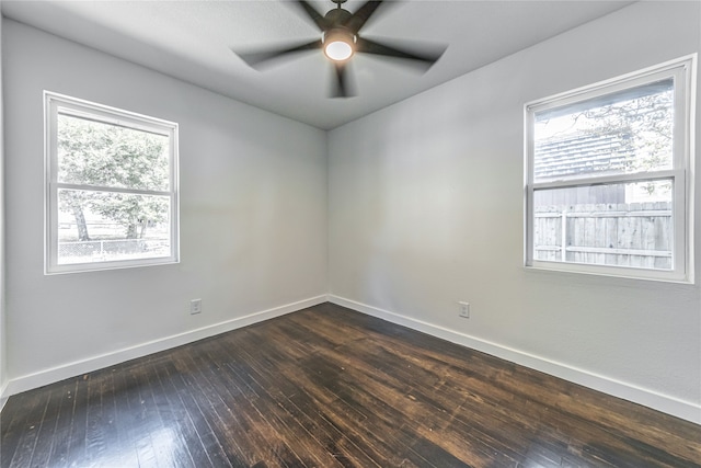 empty room with a wealth of natural light, ceiling fan, and dark hardwood / wood-style flooring