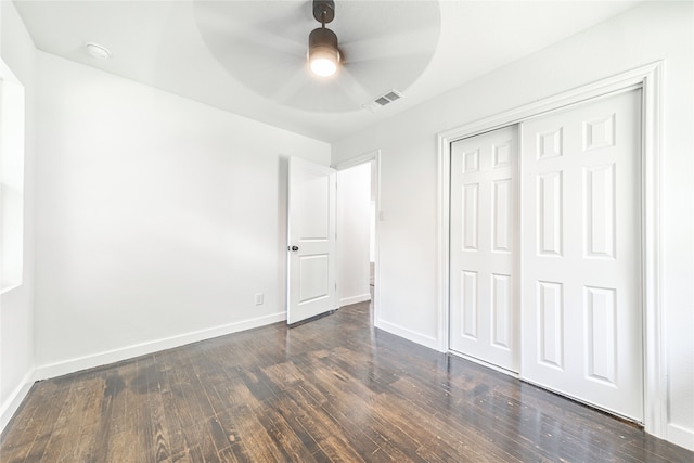 unfurnished bedroom with a closet, dark hardwood / wood-style floors, and ceiling fan