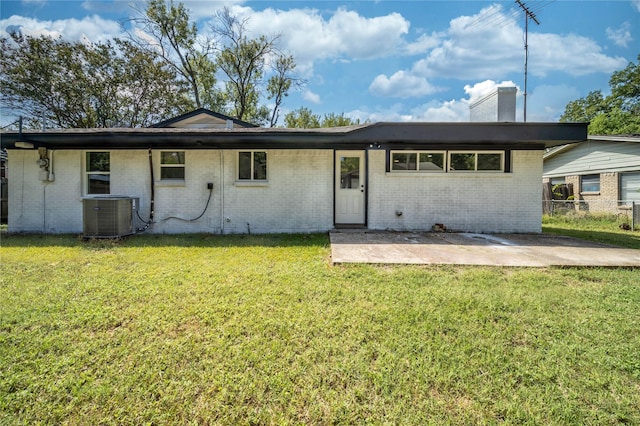 1504 Nichols St, Ennis, TX 75119 - rear view of house featuring brick siding, a chimney, and a patio area