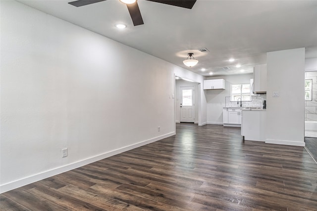 unfurnished living room with ceiling fan, dark hardwood / wood-style floors, and sink