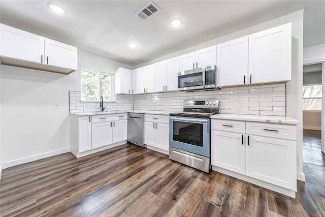 kitchen featuring white cabinets, stainless steel appliances, dark hardwood / wood-style flooring, and tasteful backsplash