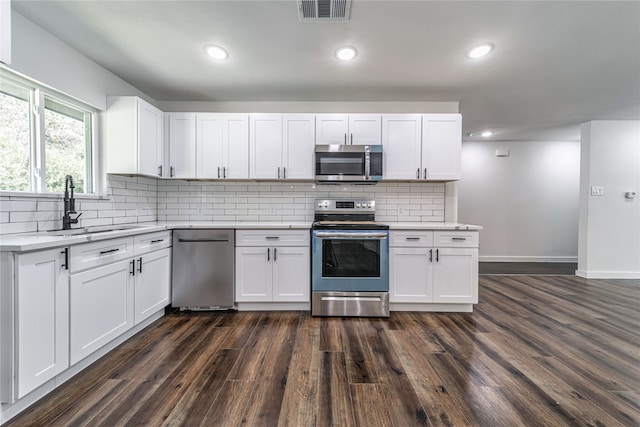 kitchen featuring white cabinets, sink, appliances with stainless steel finishes, and dark hardwood / wood-style flooring