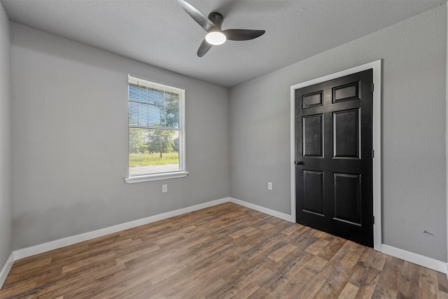 unfurnished room featuring wood-type flooring, ceiling fan, and a textured ceiling