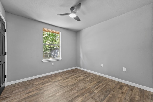 spare room with a textured ceiling, dark wood-type flooring, and ceiling fan