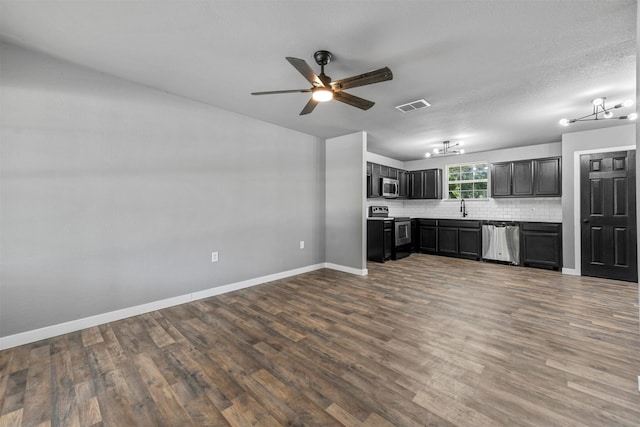 unfurnished living room with wood-type flooring, a textured ceiling, ceiling fan with notable chandelier, and sink