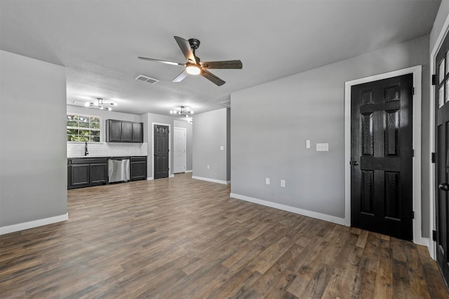 unfurnished living room with ceiling fan, dark wood-type flooring, and sink