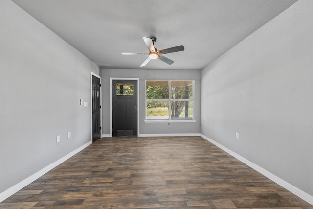 foyer entrance with a textured ceiling, dark wood-type flooring, and ceiling fan