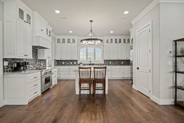 kitchen featuring an inviting chandelier, white cabinetry, designer range, and dark hardwood / wood-style floors