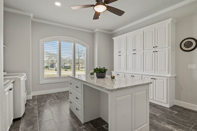 kitchen featuring separate washer and dryer, a center island, ceiling fan, and white cabinets