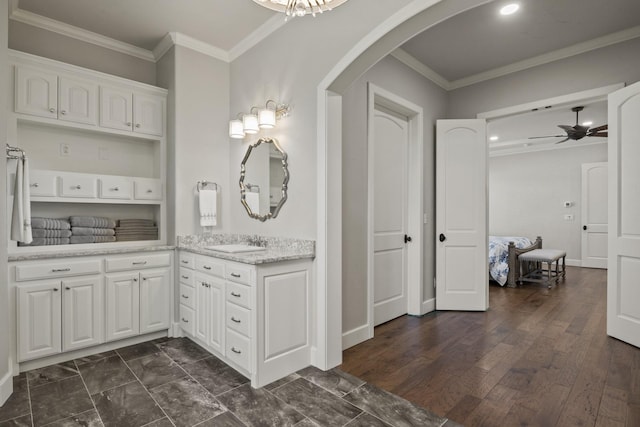 bathroom featuring a ceiling fan, vanity, crown molding, and wood finished floors