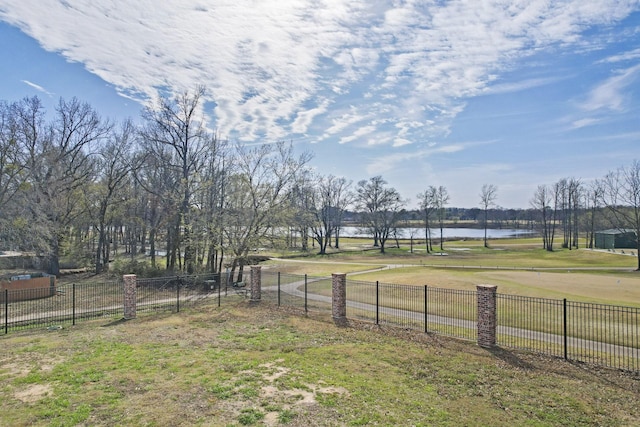 view of yard featuring a water view and fence