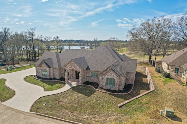 french country home featuring a front lawn and a water view