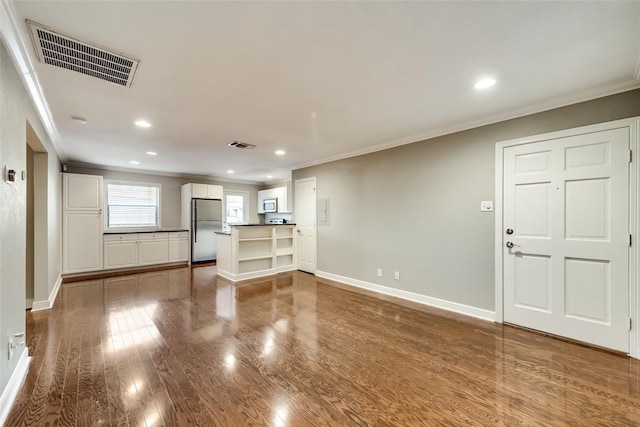 unfurnished living room with wood-type flooring and crown molding