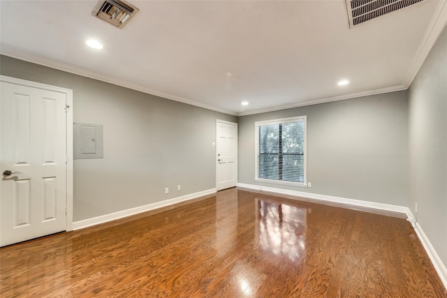 spare room with electric panel, crown molding, and hardwood / wood-style floors