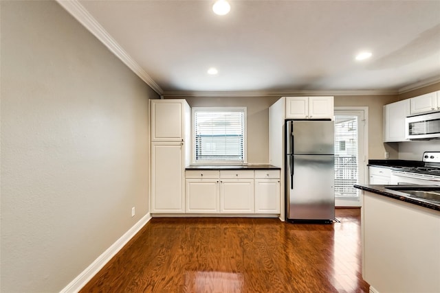 kitchen featuring appliances with stainless steel finishes, a healthy amount of sunlight, dark hardwood / wood-style floors, and white cabinets