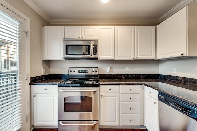 kitchen featuring appliances with stainless steel finishes, crown molding, dark stone counters, and white cabinets