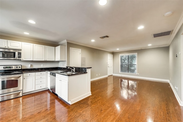 kitchen featuring white cabinetry, stainless steel appliances, crown molding, hardwood / wood-style floors, and sink