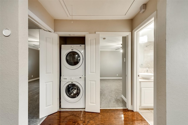 laundry area featuring carpet floors, sink, and stacked washer and dryer