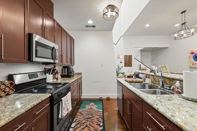 kitchen with light stone counters, sink, a notable chandelier, stainless steel appliances, and decorative light fixtures