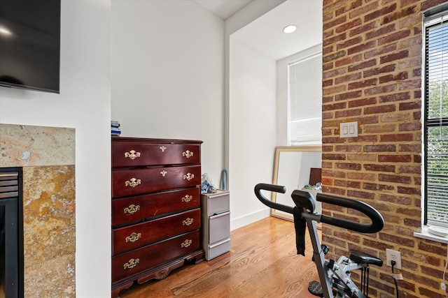 interior space with light wood-type flooring and brick wall