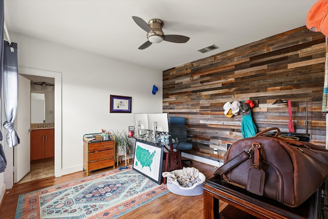 office area with wooden walls, sink, ceiling fan, and hardwood / wood-style flooring