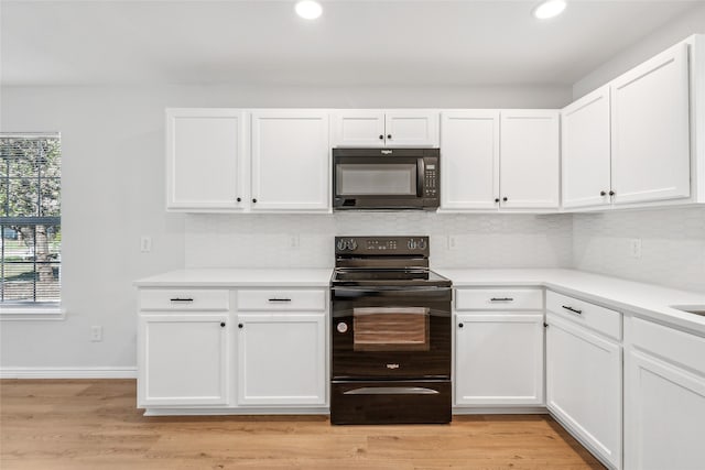 kitchen featuring black appliances, tasteful backsplash, light hardwood / wood-style flooring, and white cabinets