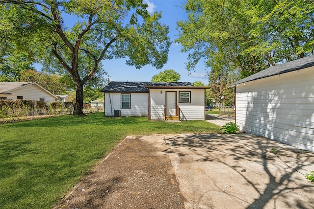 rear view of property with central AC unit, a lawn, and a patio