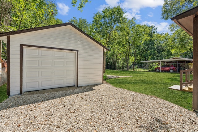 garage featuring a lawn, a carport, and wood walls