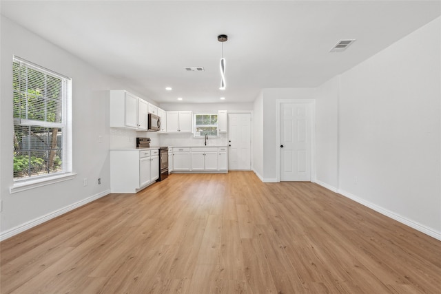 unfurnished living room with sink and light hardwood / wood-style flooring