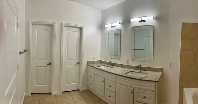 bathroom featuring a tub to relax in, tile patterned flooring, and vanity