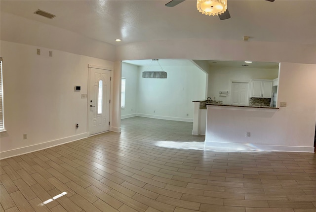 unfurnished living room with light wood-type flooring and ceiling fan